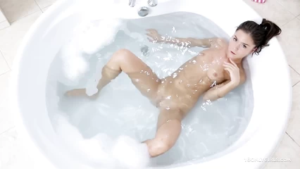 Брюнетка принимает пенную ванну